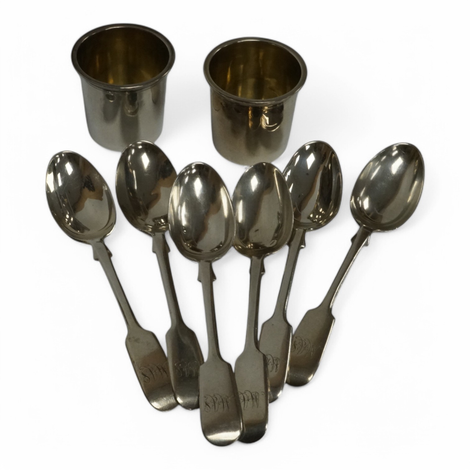 A set of late Victorian silver fiddle pattern teaspoons, by Josiah Williams & Co, London, 1896, together with two French white metal tots. Condition - fair